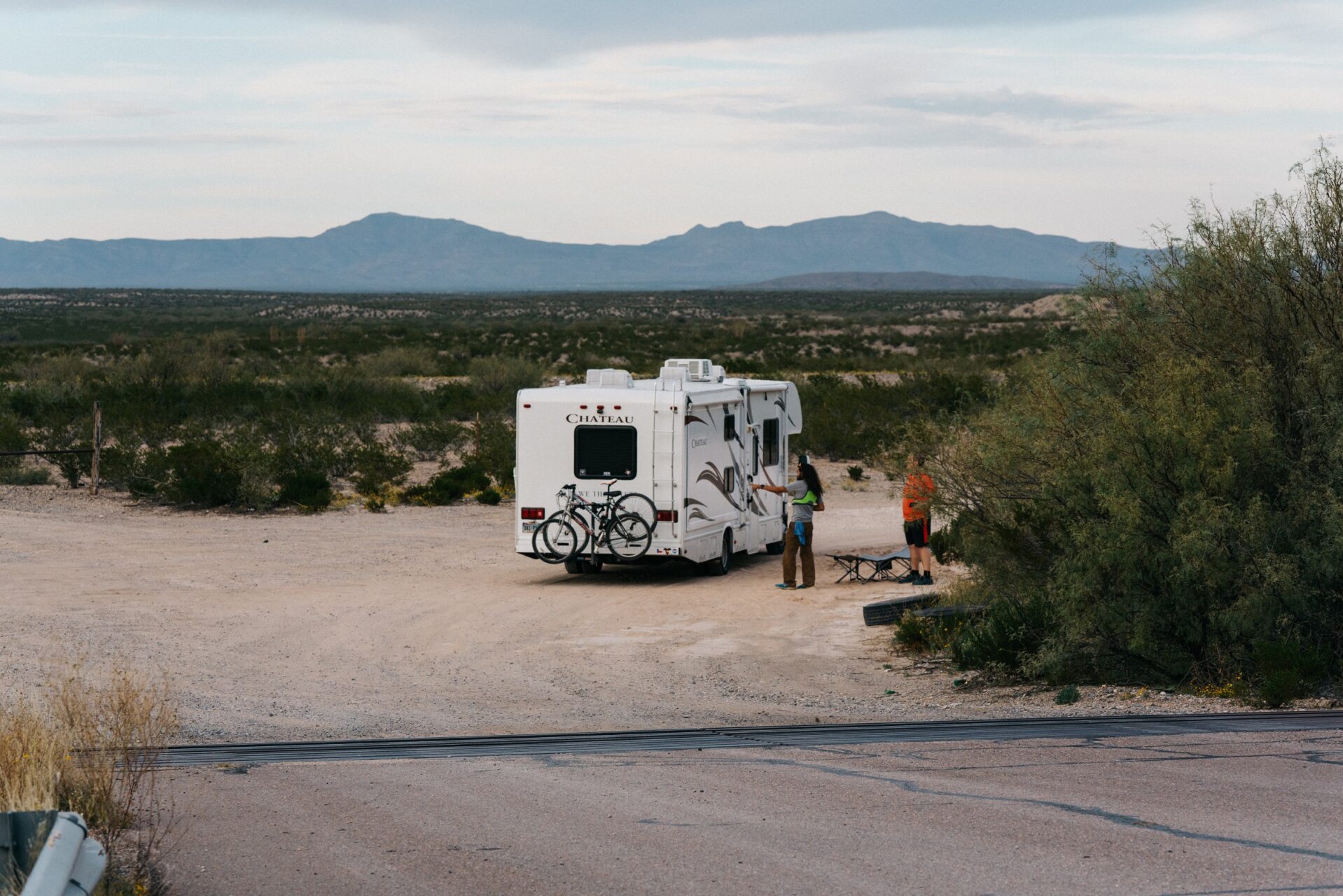Man pointing at caravan, while standing next to another man.